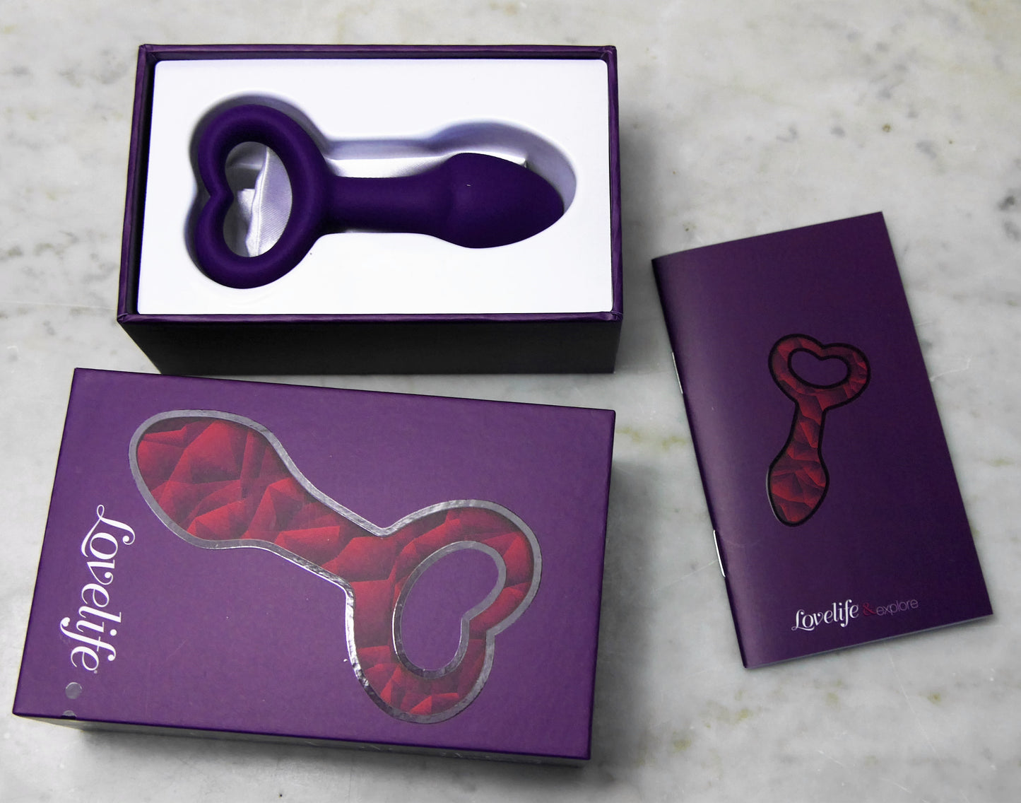 Roze buttplug met hartvormige basis van De Paarse Keizerin op witte achtergrond