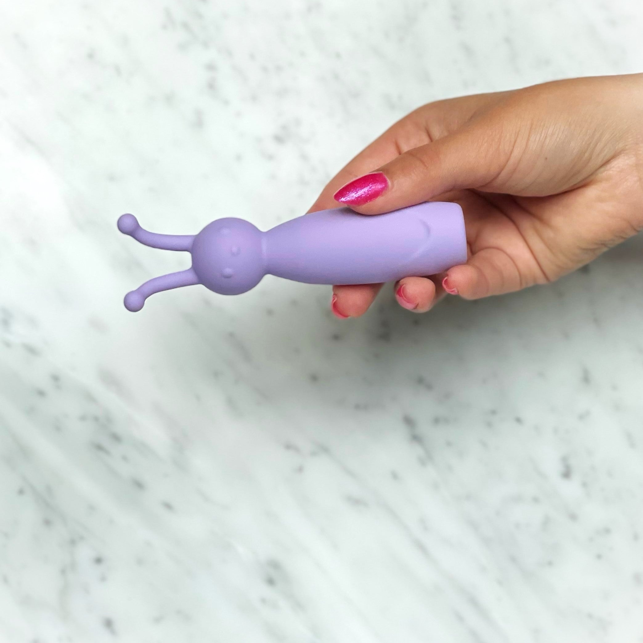 Zijaanzicht van compacte paarse Lila Bee vibrator met ergonomisch ontwerp voor discrete wellness