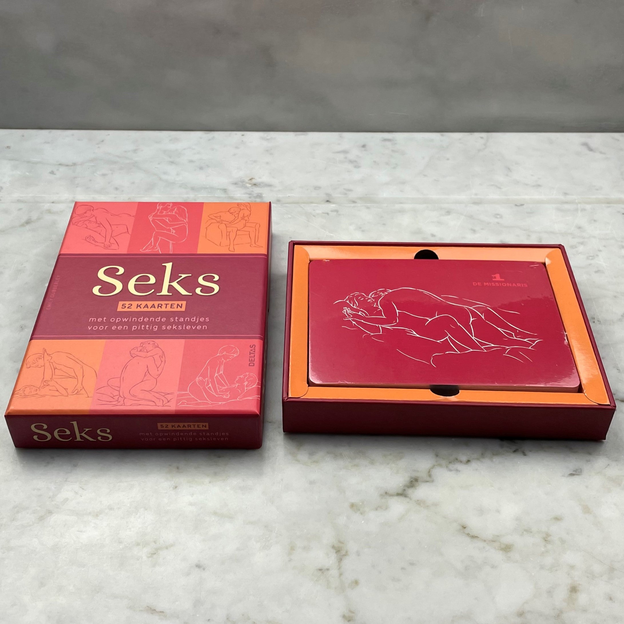 Geopende kaartenbox met De Missionaris kaart bovenop, donkerrode achtergrond